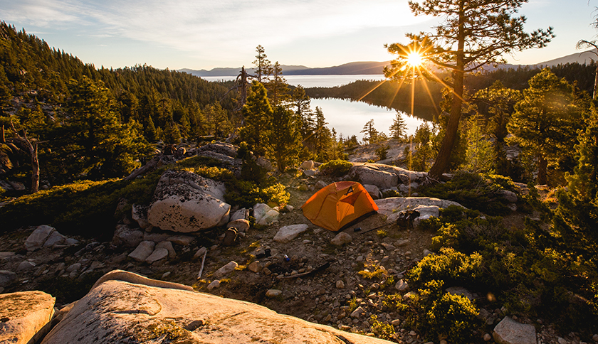 oranje tent staat tussen de stenen in de wildernis