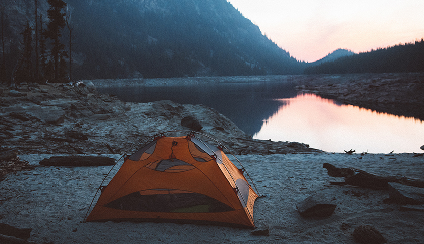 oranje tent staat naast het meer