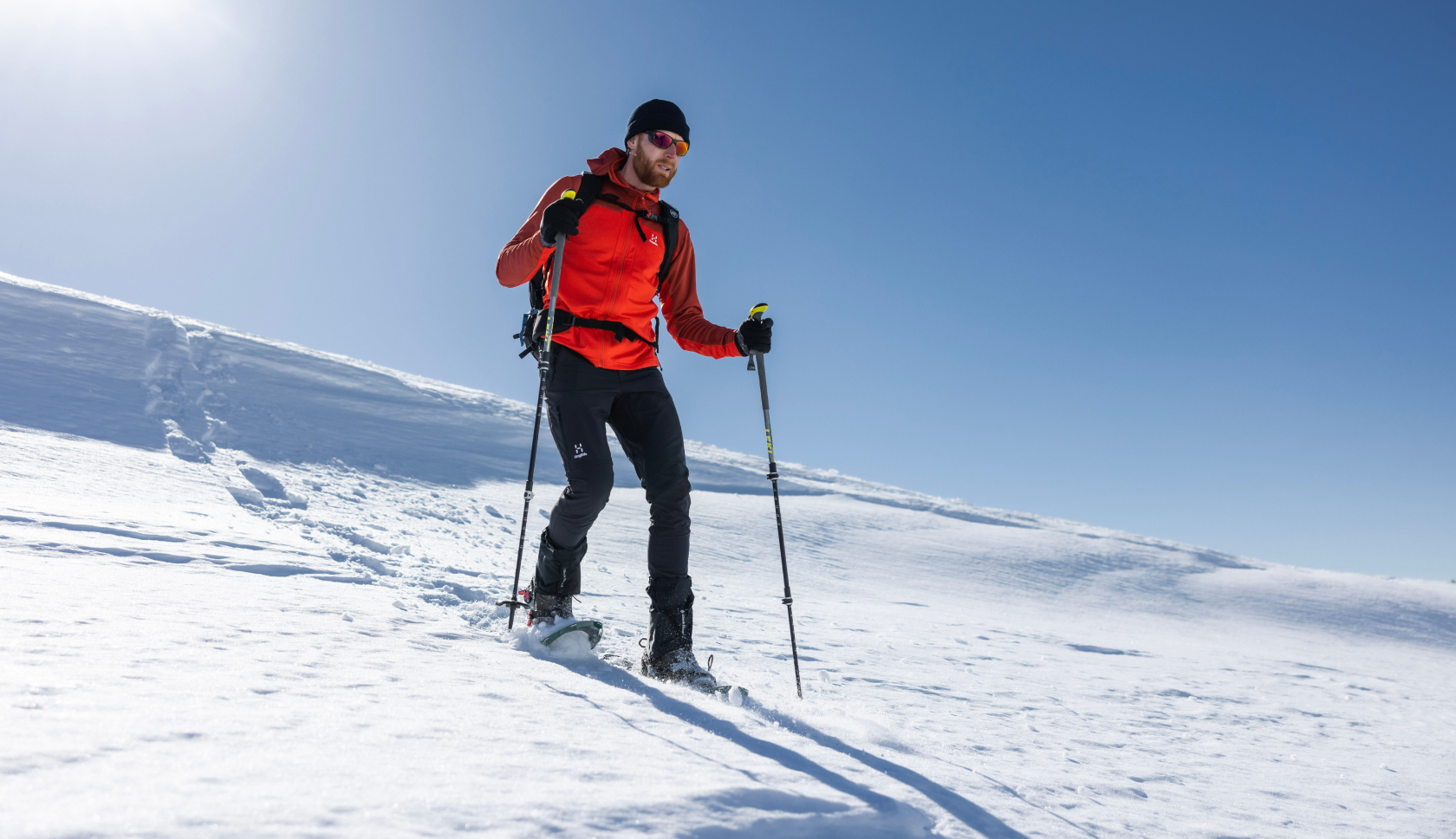 man in sneeuschoenen wandelt over besneeuwde berg