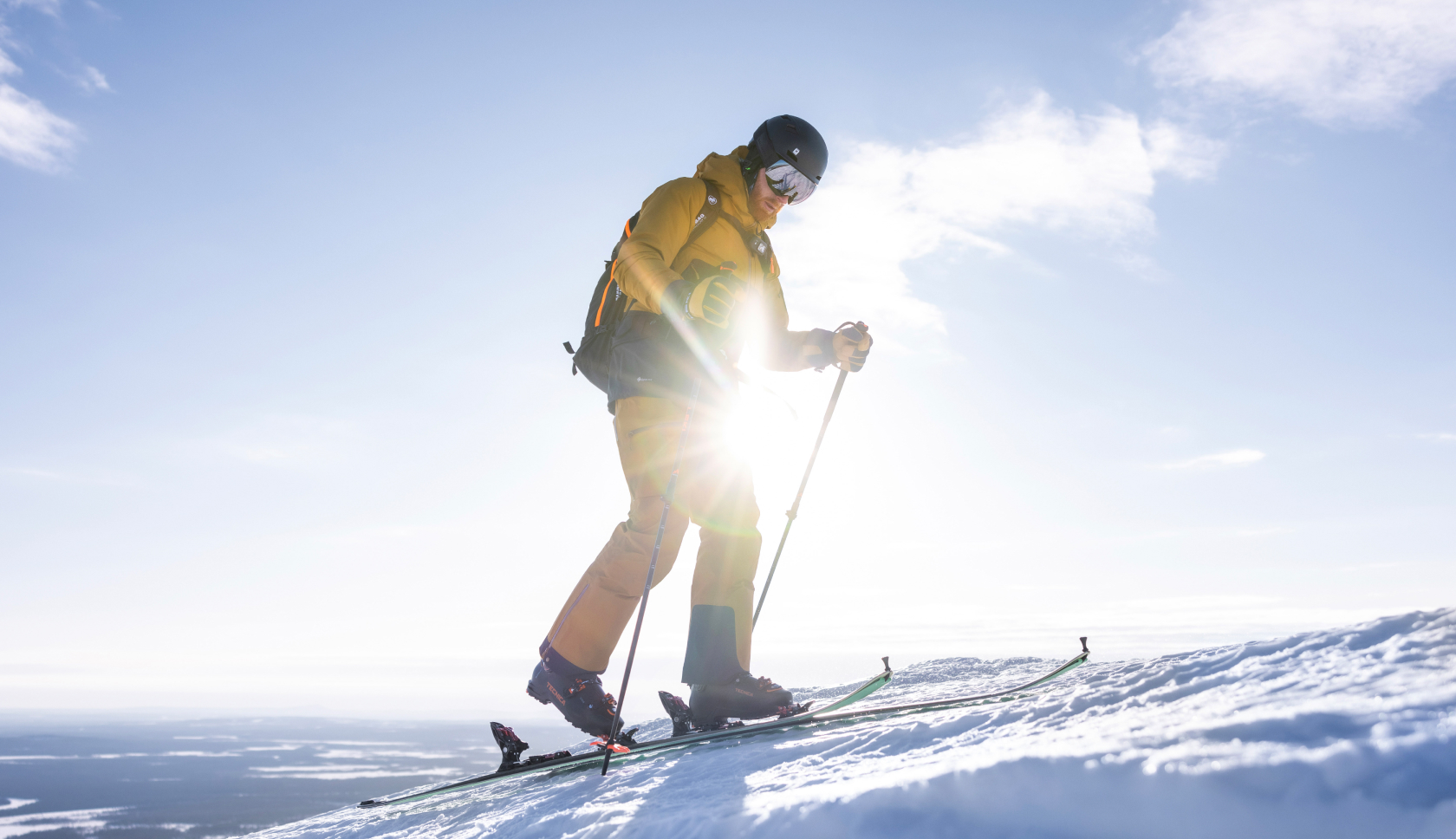wintersporter loopt op ski's een besneeuwde berg op