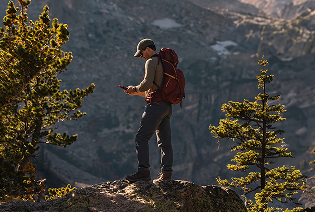 man met garmin navigatie in de bergen