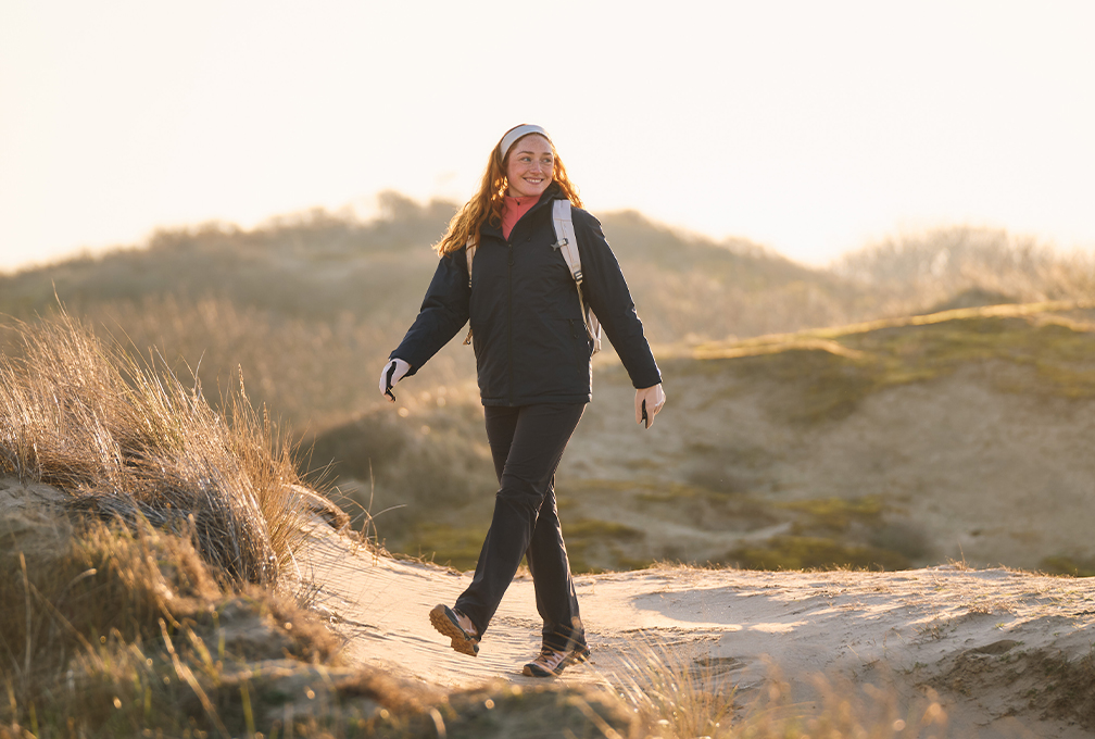 Vrouw in Maier Sports-wandelkleding tijdens een wandeling door de duinen