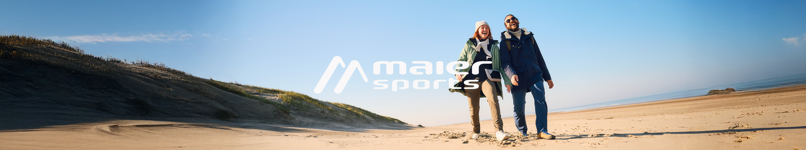 Twee wandelaars in Maier Sports-outdoorkleding op het strand