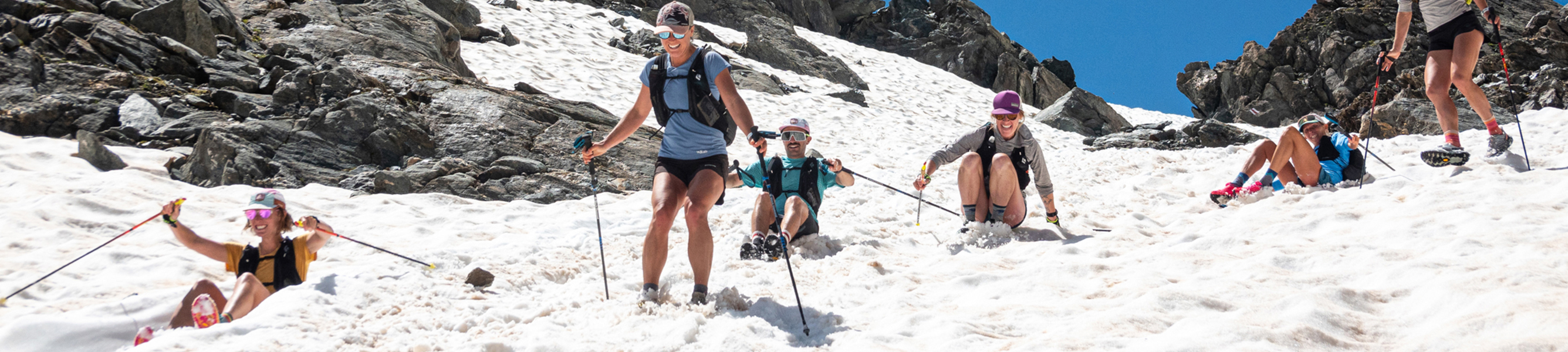 Bergsporters in Patagonia-outdoorkleding trekken door een besneeuwd berglandschap.