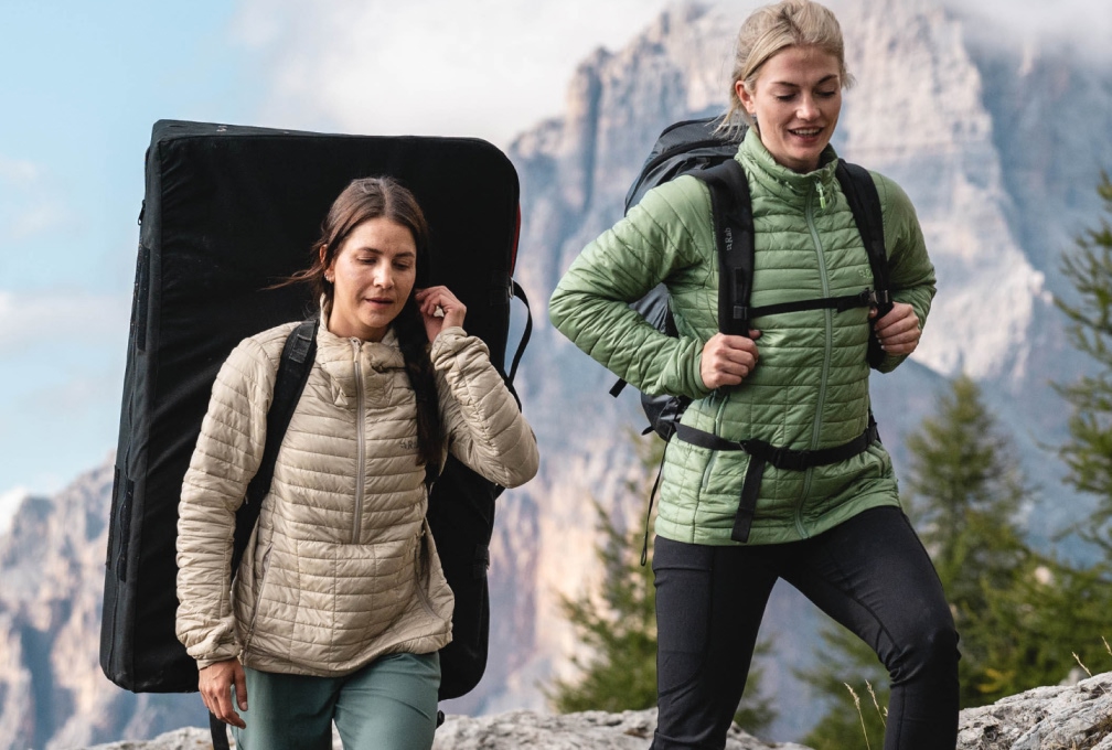 Twee vrouwen in Rab outdoorjassen met rugzakken tijdens een bergtocht