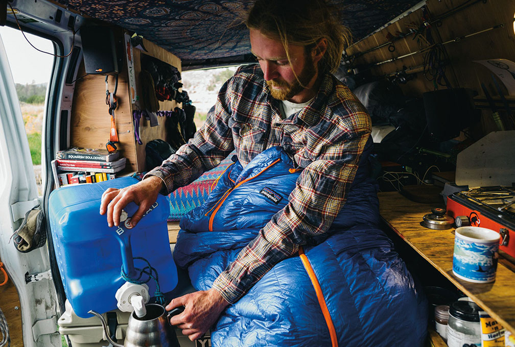 man ligt in een tent hangend aan de rotswand