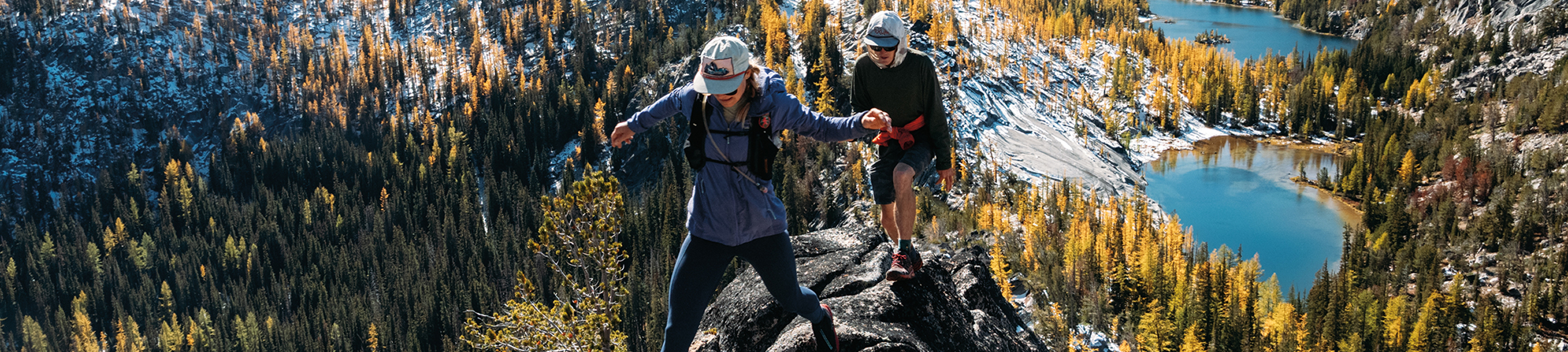 twee trailrunners staan hoog op een berg